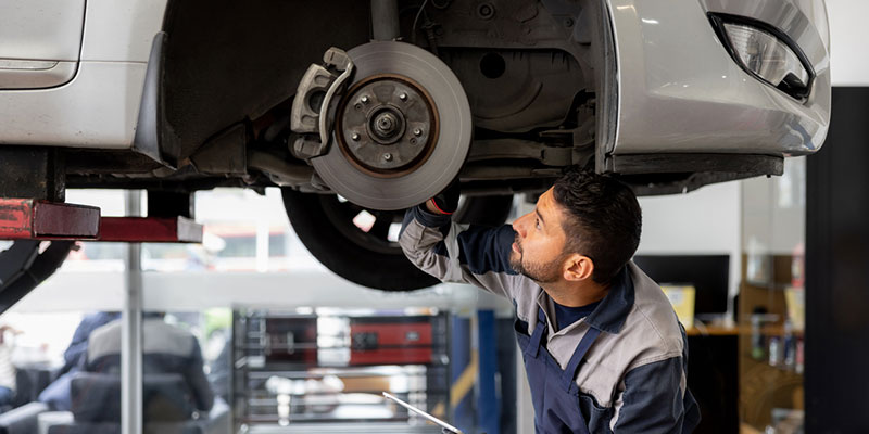 Automotive technician inspecting a brake caliper assembly